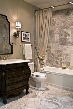 a bathroom with a toilet, sink and bathtub next to a window covered in curtains