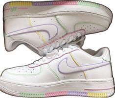 a pair of nike air force sneakers with multicolored stripes on the soles