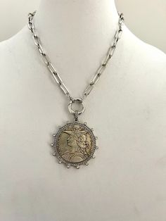 Beautiful reproduction vintage French Madagascar coin pendant in a bezel with cubic zirconia stones. The bale attached to the coin is also encrusted with CZ stones. The coin is burnished silver brass and elegantly hangs from a brass paperclip chain. The chain is attached to a spring lock clasp with Cubic Zirconia accents. The spring lock closure not only makes it easy to open and close the necklace for those with difficulty but adds to the creativity of the jewelry piece. Will enhance any outfit Silver Coin Necklace, Coin Necklace, Coin Pendant, Keep Jewelry, Cz Stone, Paper Clip, Vintage French, Madagascar, French Vintage