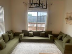 a living room filled with lots of green furniture