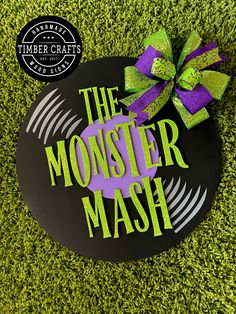 the monster mash sign with a purple and green bow sitting on top of it