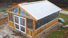 a small house with a roof made out of wood and plastic sheeting on the side