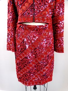 "This is an ABSOLUTELY STUNNING vintage mini skirt and matching bolero jacket! It's heavily and fully embellished with red pearls and vibrant sequins! It's in PERFECT CONDITION! This ensemble is VERY well made! Measurements: Jacket Bust - fits up to 40\" bust (while zipped) Jacket Waist - 34\" (while zipped) Jacket Length - 18\" Skirt Waist - 28\" Skirt Hips - 40\" Skirt Length - 20\" Tag Size - 10 (please refer to measurements) All of my items come from a smoke-free and pet-free home. If you ha Red Holiday Party Sets, Red Fitted Skirt Suit For Party, Red Long Sleeve Skirt Suit For Party, Red Long-sleeve Skirt Suit For Party, Embellished Red Sets For Party, Embellished Red Party Sets, Elegant Red Skirt Suit For Party, Festive Beaded Party Sets, Fitted Red Embellished Sets