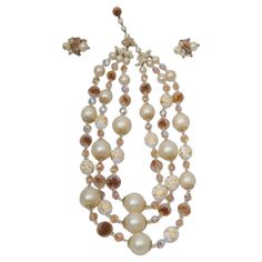 Vintage Vendome set composed of a three-strand necklace and earclips featuring large faux pearls interspersed with faceted topaz-toned and iridescent crystals and white beads with gold swirls. Adjustable clasp. Earrings with representative beads terminating with a small rhinestone and clip-on closures with adjustable screws. Pieces marked "Vendome". Three Strand Necklace, White Beads, Faux Pearl