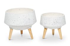 two white planters with wooden legs on a white background, one is made out of concrete and the other has speckled paint