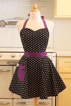 a mannequin wearing a black and white polka dot dress with purple trim around the waist