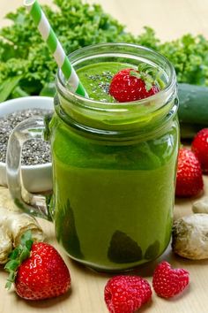 a green smoothie in a mason jar with strawberries