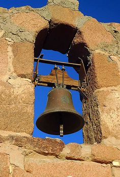 an old bell in the middle of a stone wall