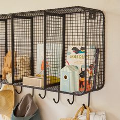 a wall mounted shelf with books and hats on it next to a hat rack filled with children's books