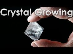 a person holding a crystal in their hand with the words crystal growing on it's side