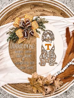 the welcome sign is on top of a basket with fall leaves and footballs around it