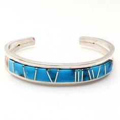 Indulge in the exceptional skill of Navaho artisan Sam Arviso with this meticulously made bracelet featuring Turquoise gemstones inlaid in a striking channel design. With a length of 5 1/4" and 1" opening, this bracelet is precisely crafted and not easily adjustable, ensuring its perfect fit. Its sleek 1/2" width and weight of approximately 27.4 grams make it a stunning and substantial piece for any jewelry collection. Blue Bangle With Polished Finish, Southwestern Style Blue Bangle Bracelets, Southwestern Style Blue Bangle Bracelet, Elegant Turquoise Bracelet With Inlay, Elegant Turquoise Inlay Bracelet, Southwestern Turquoise Gemstone Bracelets, Turquoise Gemstone Bracelet In Southwestern Style, Southwestern Turquoise Gemstone Bracelet, Blue Polished Bracelet Jewelry