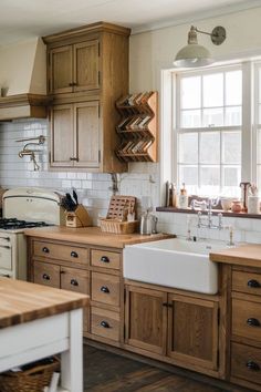 a kitchen filled with lots of wooden cabinets and counter top space next to a window