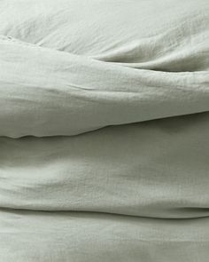 an unmade bed with white sheets and pillows