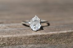 a diamond ring sitting on top of a piece of wood