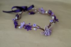 a purple flower and pearl headband on a table