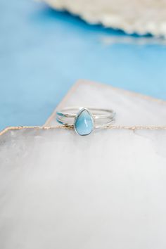 P E A R  L A R I M A R   R I N G Dainty genuine Larimar ring with a double band made of 925 sterling silver. Love it for its minimalistic design but with a pop of color!  Material: 925 Sterling Silver  *Natural, Genuine Larimar* *Stone Size 9mm x 7mm* *Nickel Free* *Hypoallergenic* This listing is for ONE ring. Photos and videos with more than one are to show variation and stacking options.  *P L E A S E  N O T E* Due to the nature of the stone, the lightness and darkness of the stone will vary as well as the stone pattern and markings.  Although it will look very similar to the photo listed, no two stones are the same. If you want to know exactly what the stone will look like in your size, please send me a message and I will be happy to send you a picture!  All of our jewelry is made with Ring Double Band, Larimar Ring, Larimar Rings, Pear Ring, Ring Gifts, Larimar Stone, Rare Stone, Everyday Rings, Stone Pattern