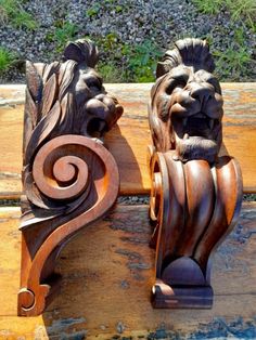 two carved wooden lions sitting on top of a bench