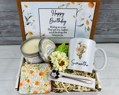 a birthday gift box with flowers, candles, and other personal care items in it