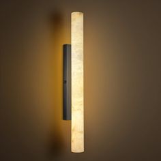 a wall mounted light that is on the side of a wall in a dark room