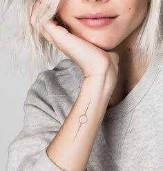 a woman with blonde hair and tattoos on her arm