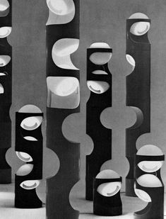 black and white photograph of abstract sculptures in an art gallery, with circles on them