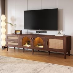 a flat screen tv sitting on top of a wooden entertainment center in a living room