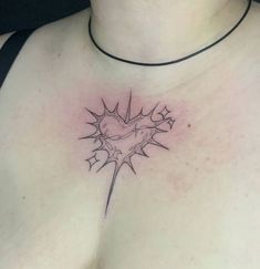 a woman's chest with a heart and lightning bolt tattoo on her left side