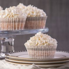 three cupcakes sitting on top of a cake plate