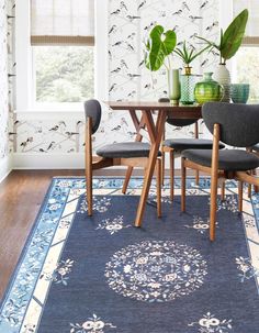 a dining room table with two chairs and a rug