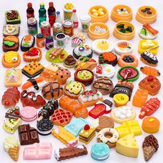 an assortment of miniature food items displayed on a white surface with confetti and candy