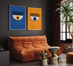 a living room with two paintings on the wall and an orange couch in front of it