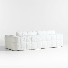 a white couch sitting on top of a white floor