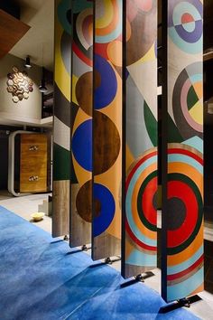 an artisticly designed room divider in the middle of a blue carpeted floor