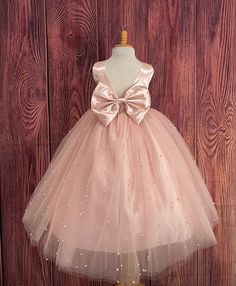 Our enchanting Ankle Length flower girl dresses are sure to turn heads! Bodice is made of Blush satin, waist consists of a matching sowed in sash (NOT DETACHABLE) The back of the dress has an open deep V-Back with a hidden zipper, followed by a detachable bow. The skirt has 4 tulle layers for fullness, the top layer of tulle consists of pearls. The dress has 2 layers of lining with crinoline. This dress is perfect for any occasion!  Dress Is Pictured with a petticoat NOT INCLUDED https://www.etsy.com/listing/1305138635/white-ankle-length-petticoat-wedding?click_key=50d449c187c9e82c565249da914d7ed38b32b9f7%3A1305138635&click_sum=17db9314&ref=shop_home_active_2 Visit our store, more items to come!  https://www.etsy.com/shop/LittledarlnBoutique?ref=profile_header CUSTOM MEASUREMENTS AVAILABLE Pink First Communion Ball Gown Dress, Pink Tulle Ball Gown For First Communion, Pink Ball Gown For First Communion, Elegant Pink Ball Gown For First Communion, Pink First Communion Ball Gown, Pink Sleeveless Tutu Dress For First Communion, Elegant Pink Pageant Dress For First Communion, Elegant Pink Tutu Dress For First Communion, Elegant Pink First Communion Dress For Pageant