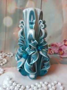 a blue and white vase sitting on top of a table next to some pearl necklaces