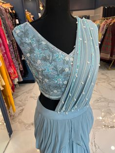 TO ORDER LARGER SIZES, PLEASE WHATSAPP +1 (945) 444-2194 Powder Blue Handwork Ready saree accentuated with pearl and bead work. Crafted with a "V" neckline and a flattering pearl and bead work on the saree pallu (ornamental end piece). paired with a trendy skirt style bottom and attached pleats. Slight variation in color is possible due to digital photography. Shipping will take 2 weeks,Please WHATSAPP +1 (945) 444-2194 for more info. Ready Saree, Moving To Dallas, Saree Pallu, Trendy Skirts, Skirt Style, New Launch, V Neckline, Style Gift, Indian Design