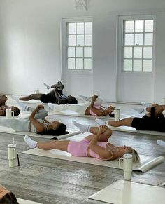 a group of people laying on their stomachs in yoga mats