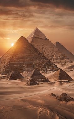 the great pyramids of giza are shown in this photo, as the sun sets over them