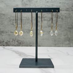 Dangly pearl earrings with hook closure in gold plated stainless steel. These gold pearl earrings come as diamond shaped pearls, rhombus shaped pearls, and oblong oval shaped pearls. They are classic bride earrings, pearl bridesmaid earrings, or dangly earrings for capsule wardrobe.   Also available in Silver: https://etsy.me/3GDblku 🌈 Pair the oblong oval shape with our multicolor gemstone and pearl necklace: https://etsy.me/46imjX1 💥 RUSH ORDER: All of our items are handmade and made to order. Our standard turnaround time is 5-7 days. If you need an item sooner, you can purchase a rush order from our shop here: https://etsy.me/47GuxKo Recommendations for maintaining your natural stone and pearl jewelry: ✅ Wipe with a soft cloth ✅ Store jewelry in a dry and protected place ✅ Take care n Pearl Charm Teardrop Earrings As Gift, Pearl Charm Drop Earrings As Gift, Adjustable Teardrop Dangle Earrings With Pearl Drop, Pearl Teardrop Earrings With Ear Wire For Gift, Gold Pearl Teardrop Earrings Gift, Adjustable Gold Teardrop Earrings, Gold Teardrop Pearl Drop Earrings Gift, Elegant Adjustable Teardrop Earrings With Pearl Drop, Adjustable Gold Teardrop Earrings With Ear Wire