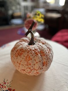 a white doily pumpkin sitting on top of a table