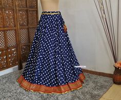 Made to Order/Made to Measurement/Custom Made Indian Lehenga Skirt (PLEASE NOTE THIS IS SKIRT ONLY) - Fabric: Polyester - Color : Navy Blue With Polka Dot Print - Fully Flared (8mtr) Kalidaar (Paneled)  Skirt - Lined - Red and Gold Banarasi Border - Drawstring closure with latkans This is Made To Order and we require following measurements in inches. 1. Waist of Skirt 2. Length of Skirt PLEASE NOTE: BUYERS ARE RESPONSIBLE FOR ANY CUSTOMS AND IMPORT TAXES THAT MAY APPLY. Fabric Care : Dry Clean Only Disclaimer: The actual color of the product might slightly differ from the image due to photographic lighting or monitor's display Shipping: This is made to order product. We customize the pattern of the dress to suit your style and fitting. Once you place the order we will provide you with a te Traditional Blue Skirt For Festivals, Traditional Fitted Tiered Skirt, Traditional Fitted Full Length Skirt, Traditional Wedding Skirt, Flowy Style, Traditional Blue Wedding Skirt, Traditional Flowy Wedding Skirt, Traditional Wedding Flowy Skirt, Festive Blue Wedding Skirt, Traditional Blue Flowy Skirt