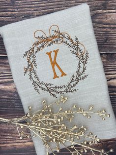 the monogrammed initial k is on top of a linen napkin next to some flowers