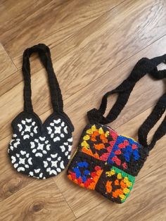 two crocheted purses sitting on top of a wooden floor next to each other