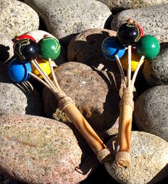 two wooden sticks sticking out of some rocks with balls on them and one stick sticking out of another