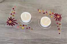 two white candles sitting on top of a glass tray