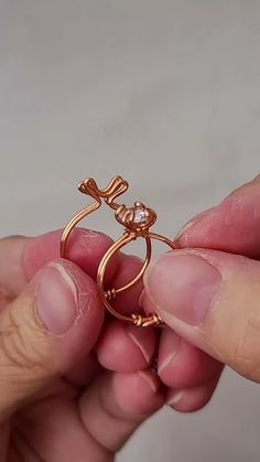 a person is holding a gold ring with a bow on it's side and an arrow in the middle