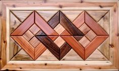 an art piece made out of wood with different shapes and colors on the surface, including squares