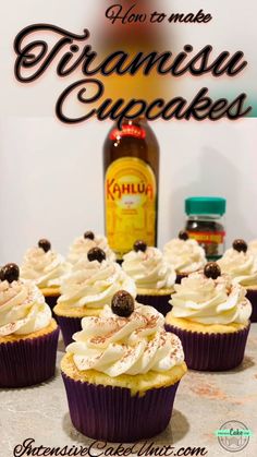 there are cupcakes with white frosting and chocolate decorations on the top, next to a bottle of booze