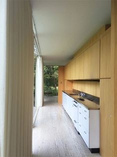 an empty kitchen with wooden cabinets and white appliances on the counter top, along with sliding glass doors leading outside